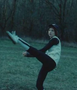 Alice, from the flim Twilight, lifts her leg very high as she throws a baseball.